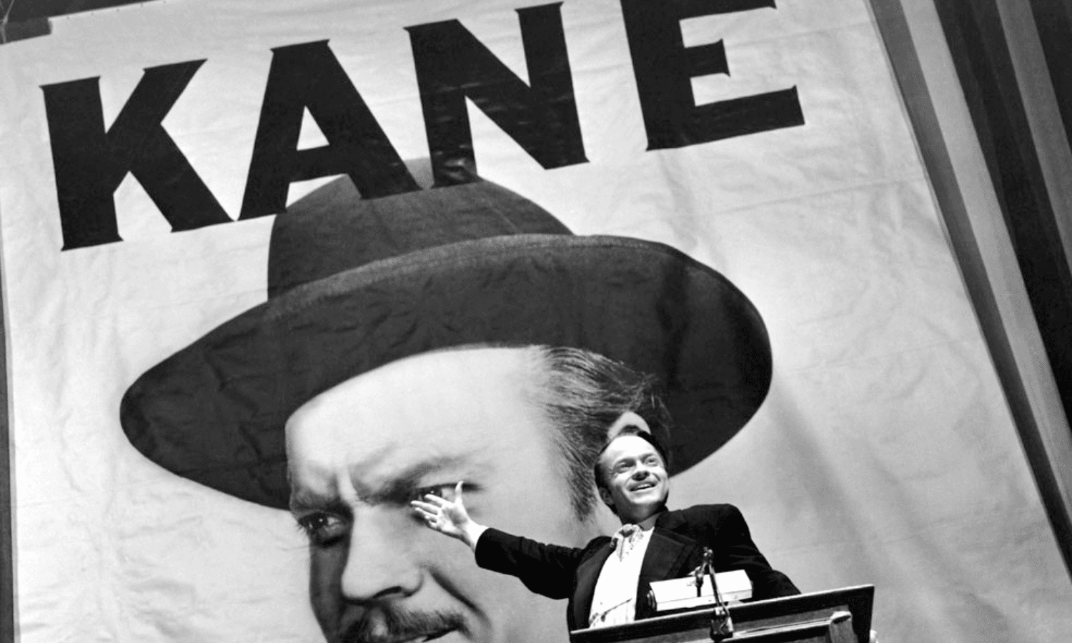 Charles Kane (protagonista de Citizen Kane) davant d'un cartell publicitari d'ell mateix, imposant-se.